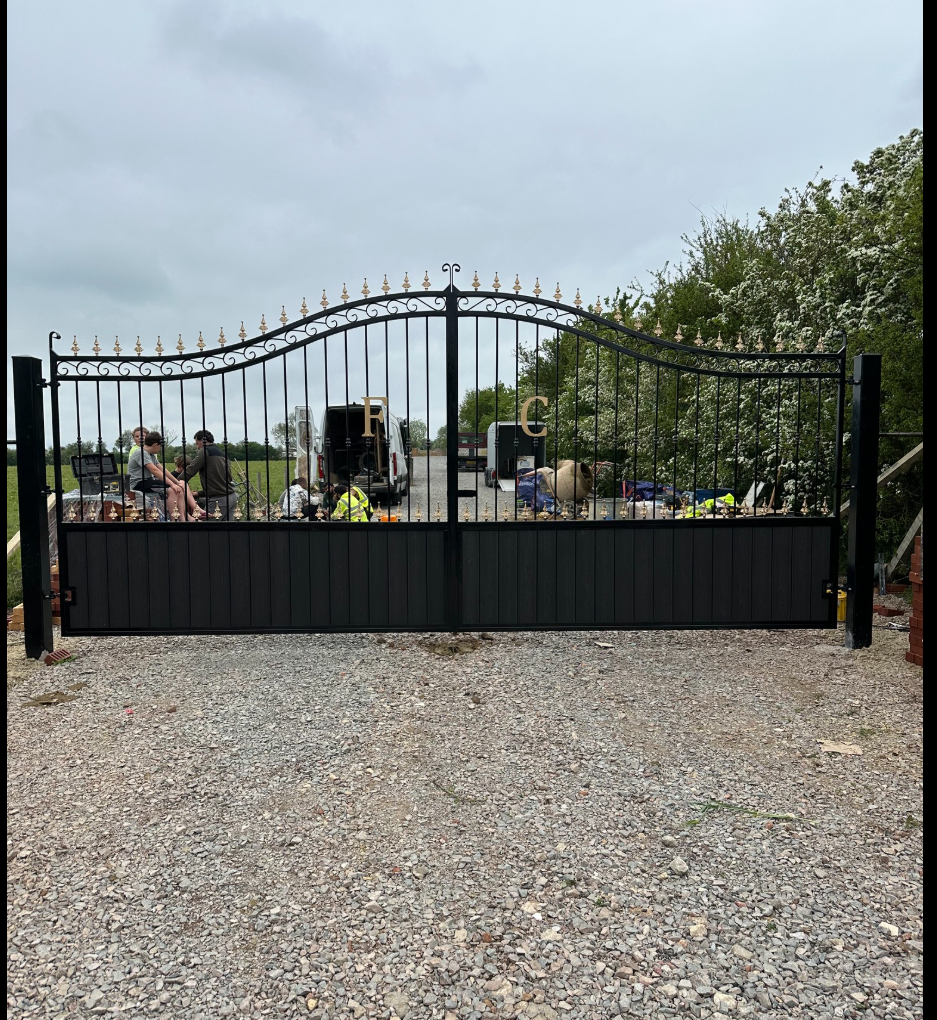 Ornate black wrought-iron driveway gates with gold finials — bespoke fabrication by SRN Fabrication.